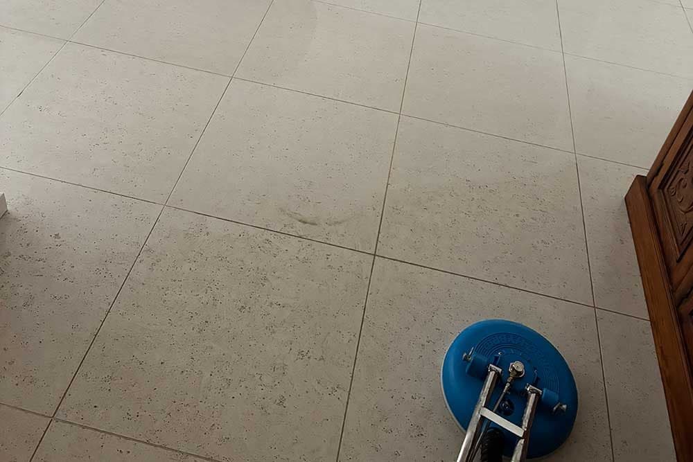 High-pressure turbo tool cleaning grout lines on a tiled floor