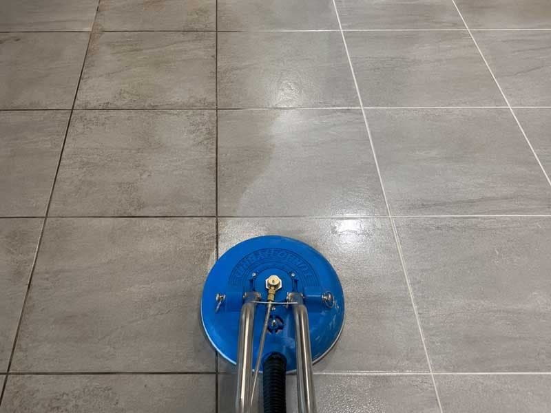 A1 turbo tool halfway across a grey tiled floor, with the cleaned grout lines visible behind it